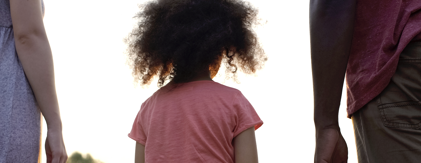Vue d’une petite fille entourée de deux adultes
