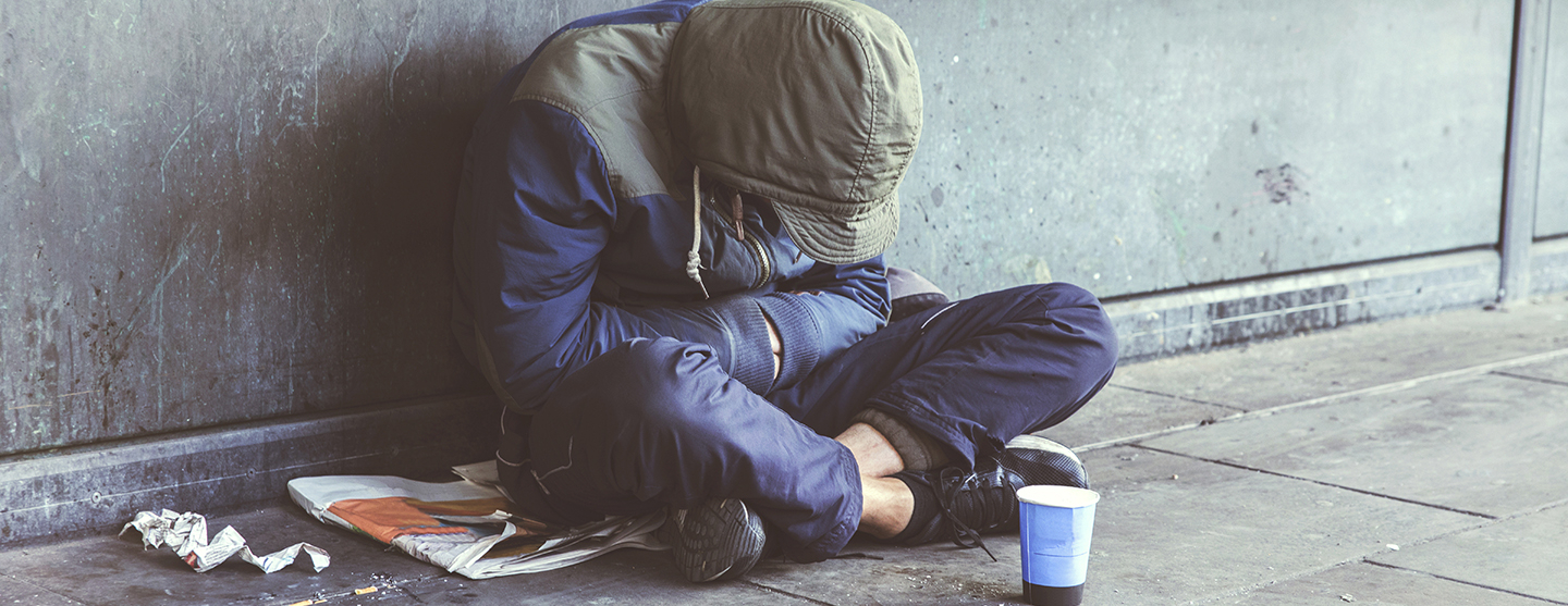 Personne assise endormie dans la rue faisant la mendicité