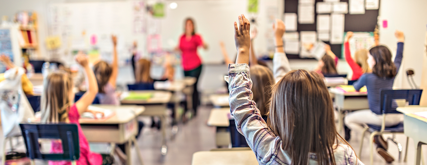 Vue d’une salle de classe avec une institutrice et des élèves