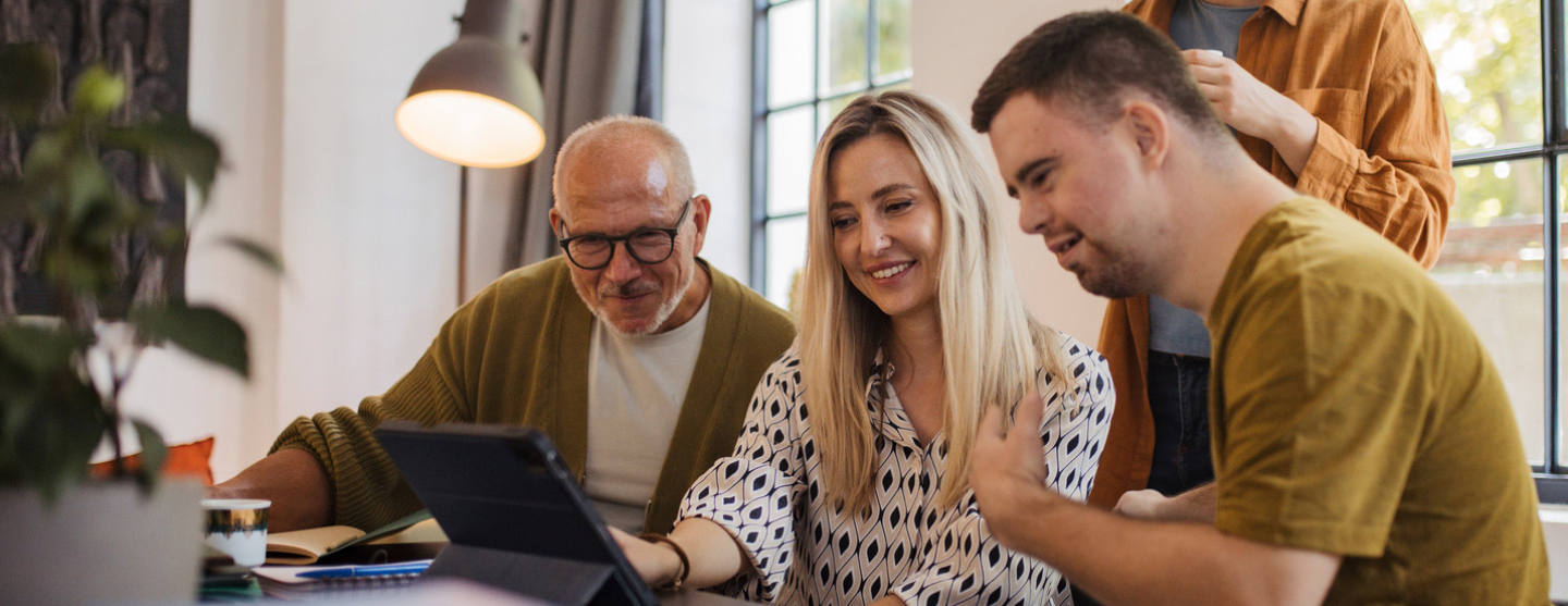 Homme handicapé entouré de collègues l'aidant dans son travail 